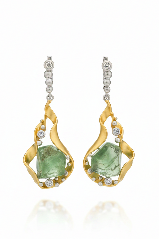 Gold earrings with green gemstones on a white background