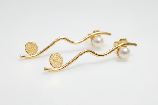 Silver earring with pearls on a light gray background