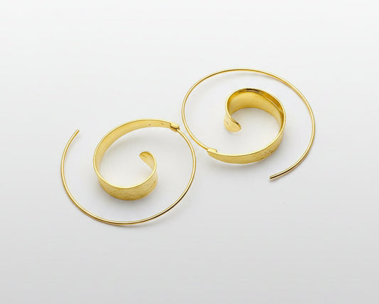 Gold spiral earrings on a light gray background