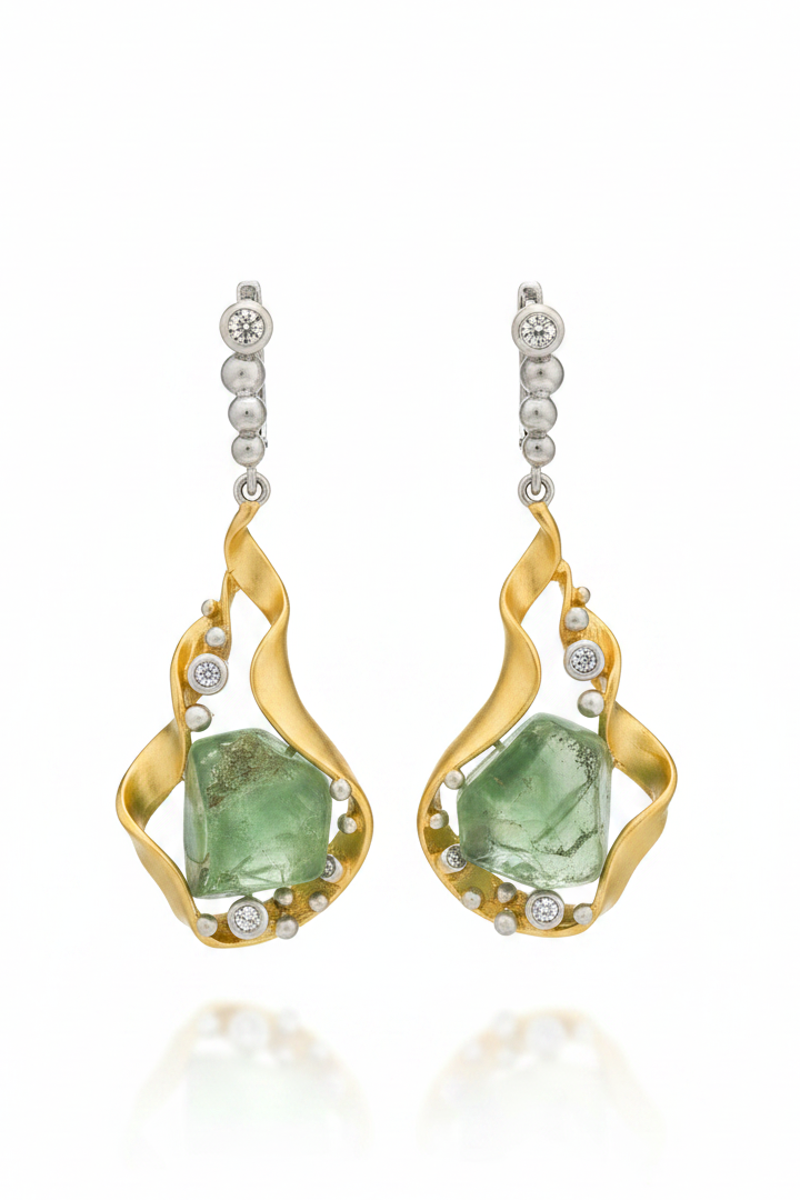 Gold earrings with green gemstones on a white background