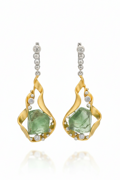 Gold earrings with green gemstones on a white background