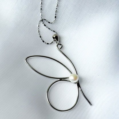 Silver butterfly pendant necklace on a light gray background