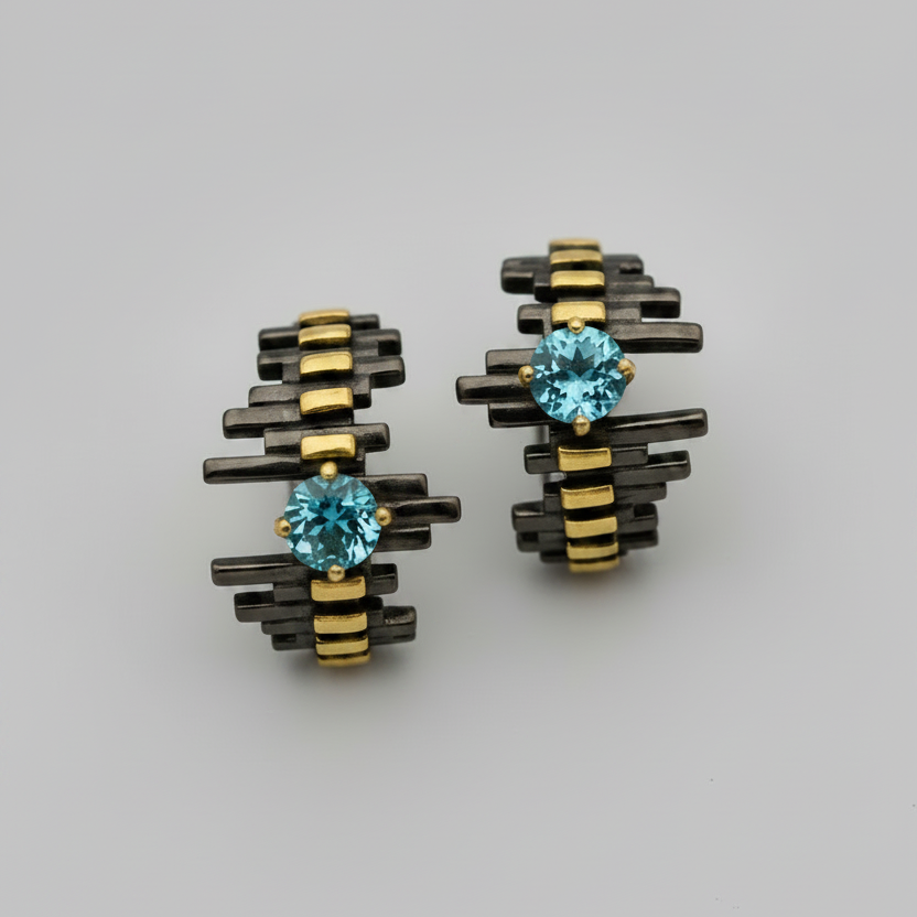 Pair of earrings with blue gemstones on a gray background