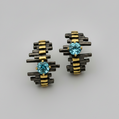Pair of earrings with blue gemstones on a gray background