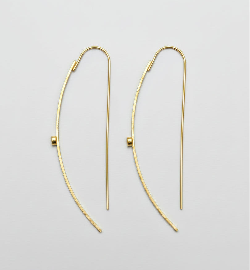 Gold hoop earrings on a light gray background