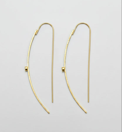 Gold hoop earrings on a light gray background