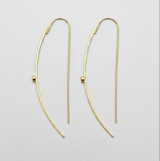 Gold hoop earrings on a light gray background