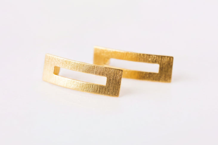 Gold rectangular cufflinks on a white background