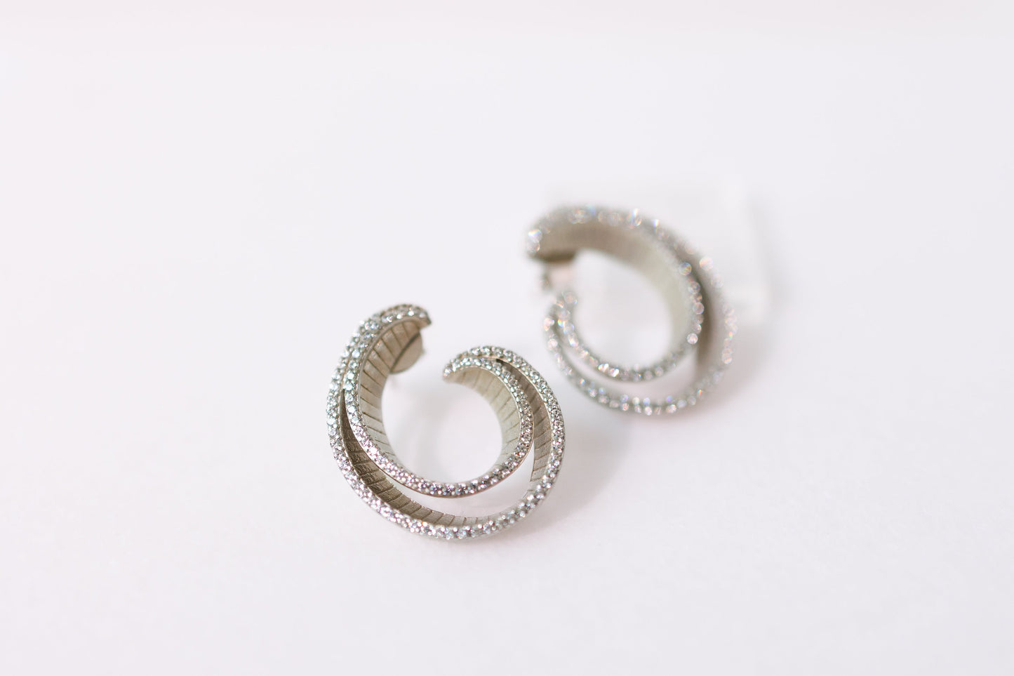 Pair of silver hoop earrings on a white background