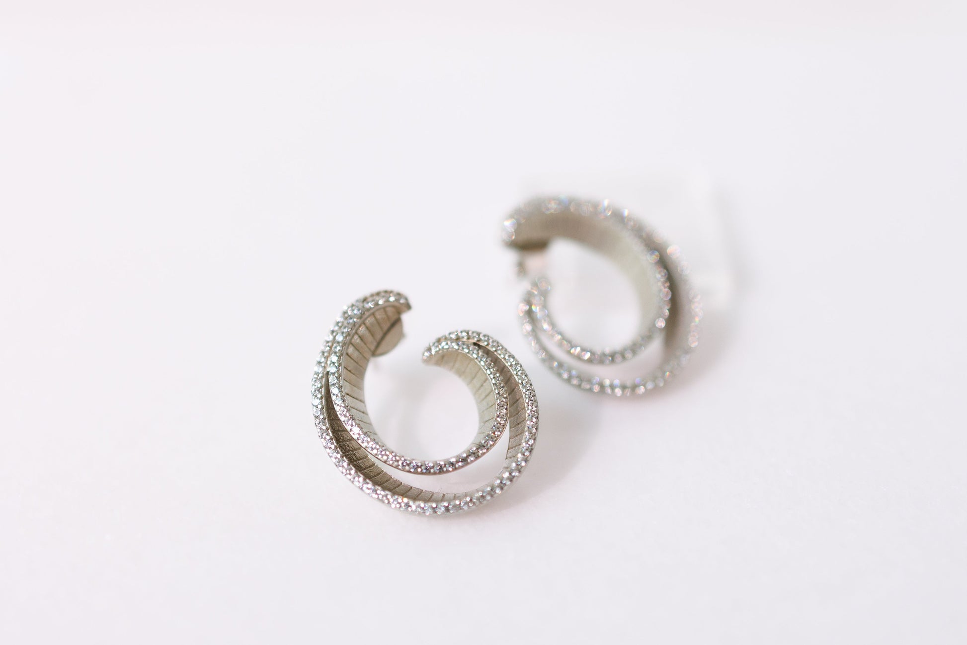 Pair of silver hoop earrings on a white background
